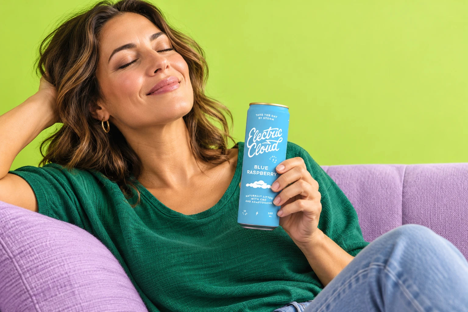 A woman relaxing on a lavender sofa with a Blue Raspberry Electric Cloud