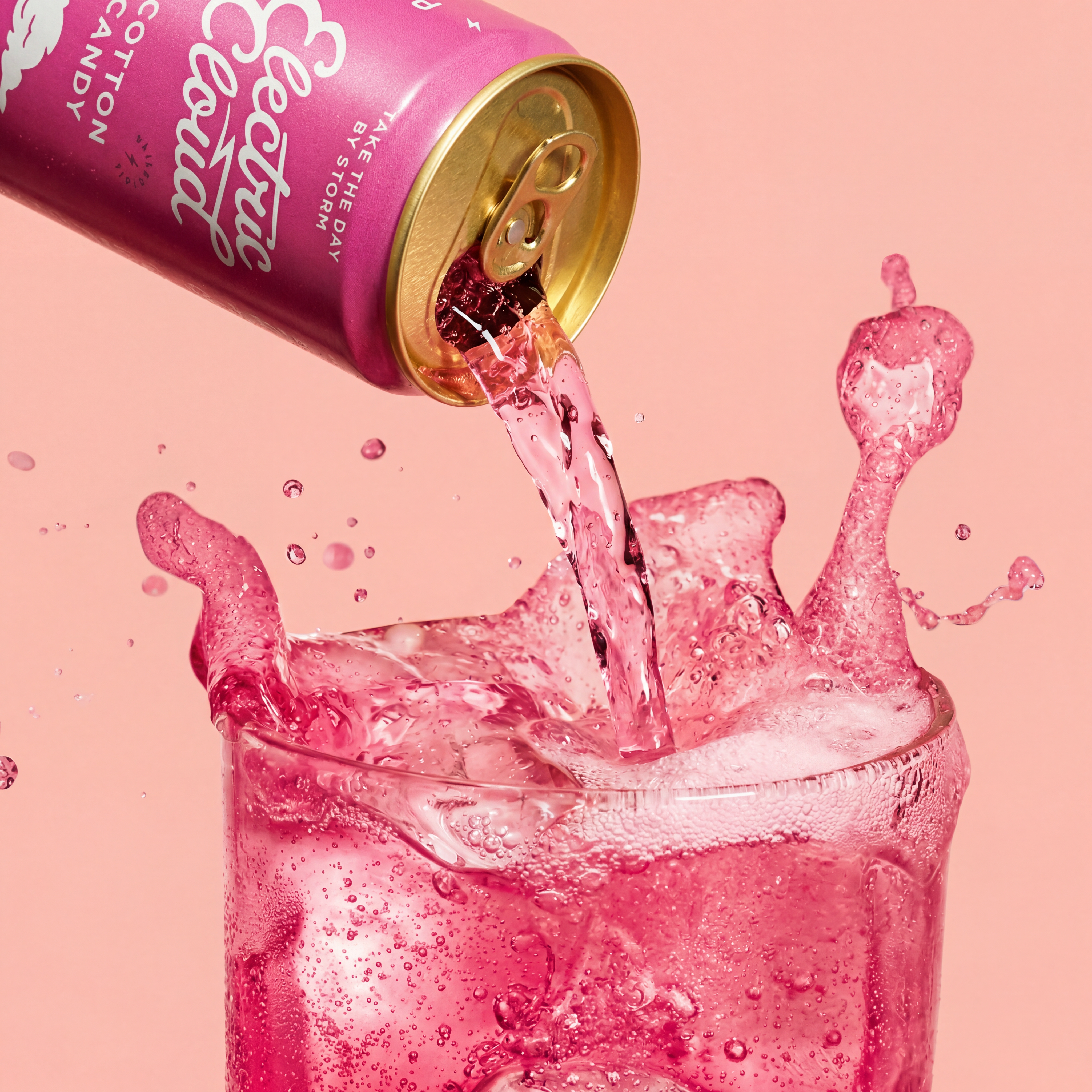 Cotton Candy Electric Cloud can being poured into a glass with cherry-pink liquid splash, on a pink studio backdrop