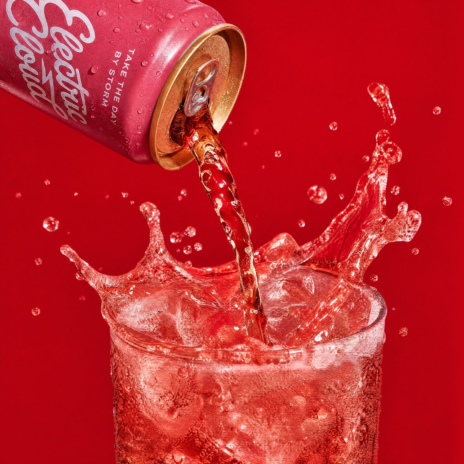 Electric Cloud Cherry Lime can pouring into a glass of ice with a dramatic splash on a deep red background